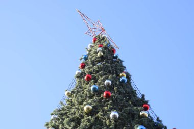 Süslemeleri yılbaşı ağacı. Tinsel ve oyuncaklar, topları ve diğer süslemeleri Noel Noel ayakta açık havada ağaç.