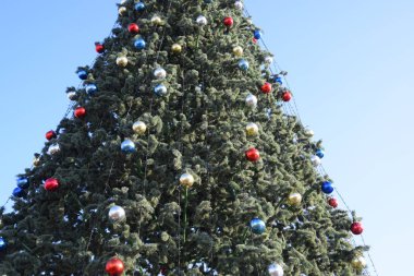 Süslemeleri yılbaşı ağacı. Tinsel ve oyuncaklar, topları ve diğer süslemeleri Noel Noel ayakta açık havada ağaç.
