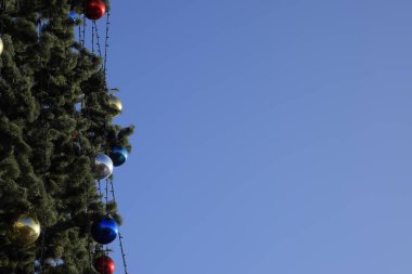 Süslemeleri yılbaşı ağacı. Tinsel ve oyuncaklar, topları ve diğer süslemeleri Noel Noel ayakta açık havada ağaç.