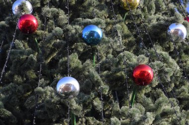 Süslemeleri yılbaşı ağacı. Tinsel ve oyuncaklar, topları ve diğer süslemeleri Noel Noel ayakta açık havada ağaç.