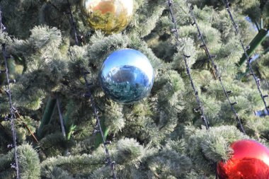 Süslemeleri yılbaşı ağacı. Tinsel ve oyuncaklar, topları ve diğer süslemeleri Noel Noel ayakta açık havada ağaç.