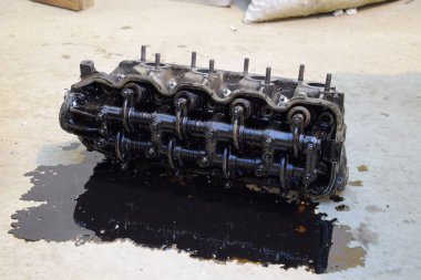 Silindir bloğunun başı. Silindir bloğunun başı tamir için motordan çıkarıldı. Motor yağının parçaları. Araç motoru tamiri serviste..