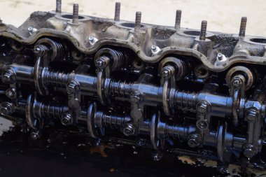 Silindir bloğunun başı. Silindir bloğunun başı tamir için motordan çıkarıldı. Motor yağının parçaları. Araç motoru tamiri serviste..