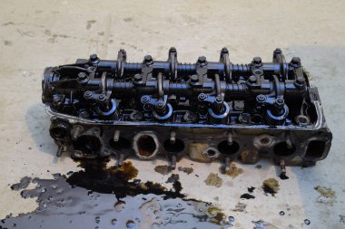 Silindir bloğunun başı. Silindir bloğunun başı tamir için motordan çıkarıldı. Motor yağının parçaları. Araç motoru tamiri serviste..
