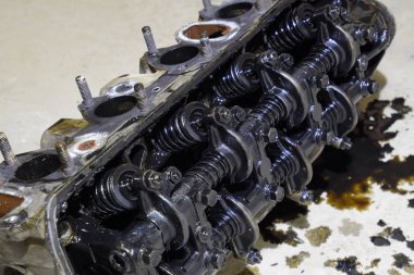 Silindir bloğunun başı. Silindir bloğunun başı tamir için motordan çıkarıldı. Motor yağının parçaları. Araç motoru tamiri serviste..