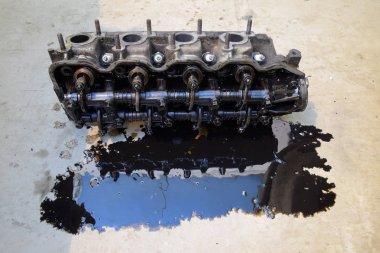 Silindir bloğunun başı. Silindir bloğunun başı tamir için motordan çıkarıldı. Motor yağının parçaları. Araç motoru tamiri serviste..