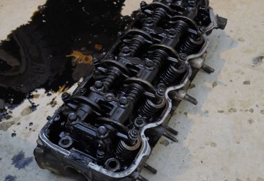 Silindir bloğunun başı. Silindir bloğunun başı tamir için motordan çıkarıldı. Motor yağının parçaları. Araç motoru tamiri serviste..