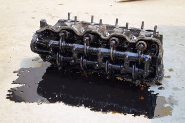 Silindir bloğunun başı. Silindir bloğunun başı tamir için motordan çıkarıldı. Motor yağının parçaları. Araç motoru tamiri serviste..