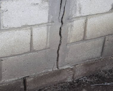 Beton duvar bir çatlak. Gri bloklar duvardan imha.