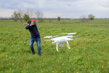 Bir adam kendini bir dron ile bir çarpışma dan gizler. Quadrocopter kişiye uçar