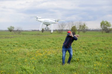 Bir adam kendini bir dron ile bir çarpışma dan gizler. Quadrocopter kişiye uçar
