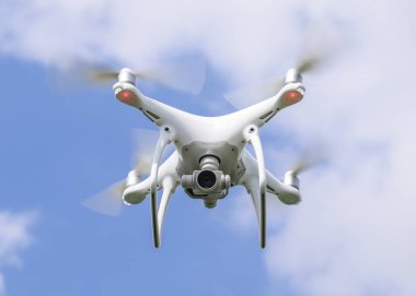 Uçuş quadrocopters beyaz bulutlar ile mavi gökyüzüne karşı