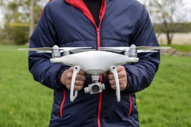 Quadrocopter onun elinde olan bir adam. Beyaz bir dron p ediliyor