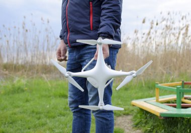 Quadrocopter onun elinde olan bir adam. Beyaz bir drone uçuş için hazırlanıyor. Hayalet.
