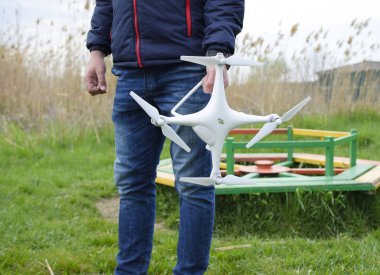 Quadrocopter onun elinde olan bir adam. Beyaz bir drone uçuş için hazırlanıyor. Hayalet.