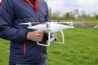 Quadrocopter onun elinde olan bir adam. Beyaz bir drone uçuş için hazırlanıyor. Hayalet.