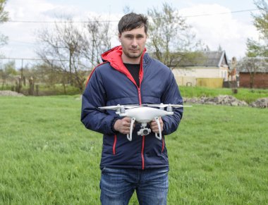 Quadrocopter onun elinde olan bir adam. Beyaz bir drone uçuş için hazırlanıyor. Hayalet.