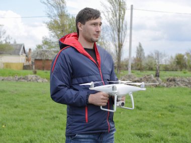 Quadrocopter onun elinde olan bir adam. Beyaz bir drone uçuş için hazırlanıyor. Hayalet.