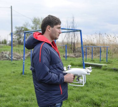 Quadrocopter onun elinde olan bir adam. Beyaz bir drone uçuş için hazırlanıyor. Hayalet.