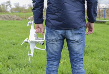 Quadrocopter onun elinde olan bir adam. Beyaz kvadrokopter hazırlamak için uçuş