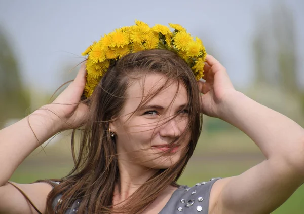 Bir kızla dandelions başında bir çelenk. Güzel peri genç kız lale çiçekleri arasında bir alanda. — Stok fotoğraf