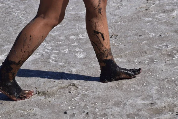 腿行走的女孩在盐湖的干底 在干湖的底部有盐和泥的行走的女人 古代干涸的湖泊 — 图库照片