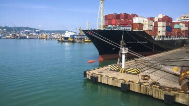 Küçük bir gemi liman iskeleye demirlemiş