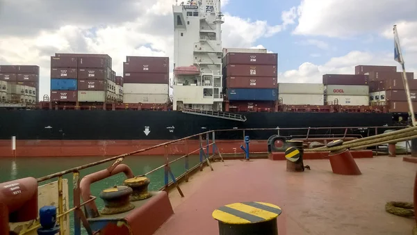 Un barco con contenedores de carga a bordo. Vista del buque de carga desde la cubierta del lugar de amarre . —  Fotos de Stock