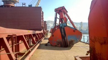 Hangi yükleme vinç pota yatıyor gemi güverte. Endüstriyel bağlantı noktası yükleme ekipmanları.