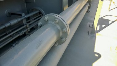 Flanşlı bağlantı üzerinde gri bir boru. Geminin güvertesinde borular.
