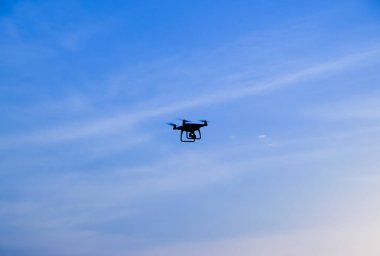 Quadrocopters siluet güneşin arka planı. Akşam gökyüzünde uçan uçaklar.