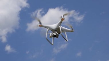 İle DJI indeks işlem Phantom 4 uçuş robot. Quadrocopter beyaz bulutlar ile mavi gökyüzüne karşı. Gökyüzünde helikopter uçuş.