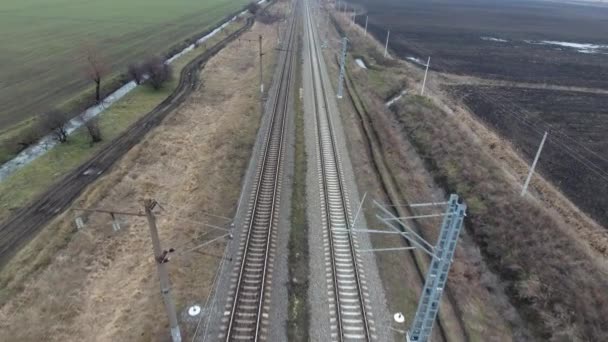 Järnvägen. Loppet över järnvägen spårar. Rails och järnvägssyllar, högspänd elektrisk kraftledning — Stockvideo