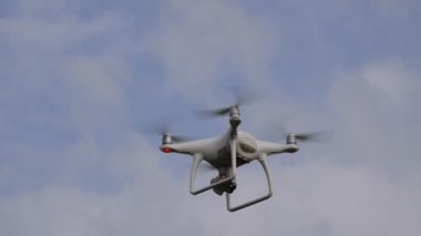 İle DJI indeks işlem Phantom 4 uçuş robot. Quadrocopter beyaz bulutlar ile mavi gökyüzüne karşı. Gökyüzünde helikopter uçuş.