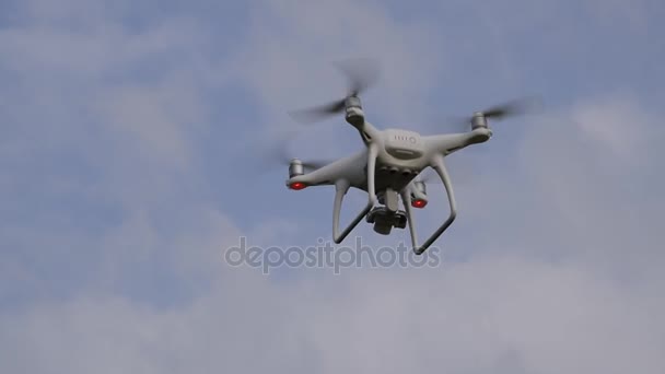 İle DJI indeks işlem Phantom 4 uçuş robot. Quadrocopter beyaz bulutlar ile mavi gökyüzüne karşı. Gökyüzünde helikopter uçuş. — Stok video