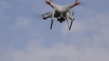 İle DJI indeks işlem Phantom 4 uçuş robot. Quadrocopter beyaz bulutlar ile mavi gökyüzüne karşı. Gökyüzünde helikopter uçuş.