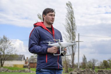 Quadrocopter onun elinde olan bir adam. Beyaz bir drone uçuş için hazırlanıyor. Hayalet.