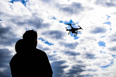 Quadrocopter onun elinde olan bir adam. Beyaz kvadrokopter hazırlamak için uçuş