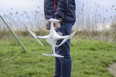 Quadrocopter onun elinde olan bir adam. Beyaz bir drone uçuş için hazırlanıyor. Hayalet.