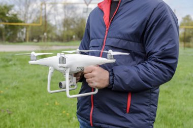 Quadrocopter onun elinde olan bir adam. Beyaz bir drone uçuş için hazırlanıyor. Hayalet.