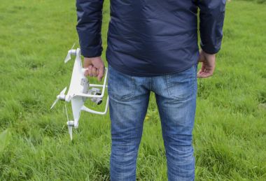 Quadrocopter onun elinde olan bir adam. Beyaz kvadrokopter hazırlamak için uçuş
