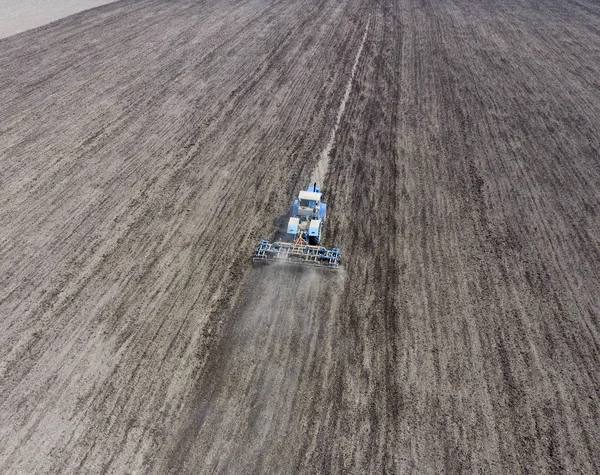 Budidaya tanah untuk menabur sereal. Traktor membajak tanah di lapangan — Stok Foto
