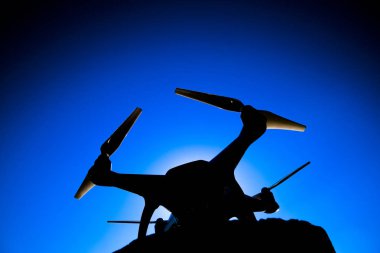 Quadrocopter Phantom 4 güneş mavi gökyüzünde karşı. Arka ışık. Dron yenilikçi bir uçan robot olduğunu.