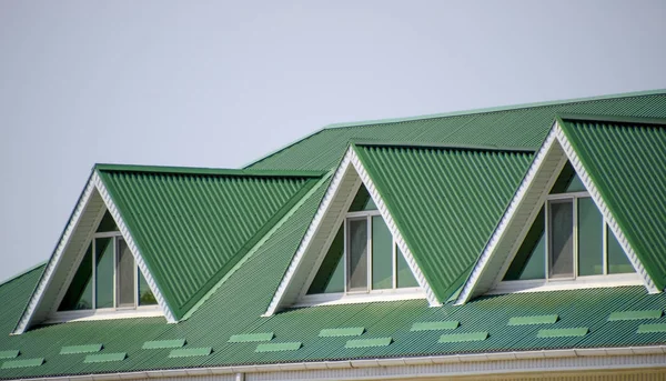 La casa con ventanas de plástico y un techo verde de chapa corrugada. Techo verde de perfil de metal corrugado y ventanas de plástico . —  Fotos de Stock