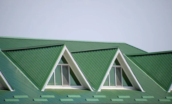 La casa con ventanas de plástico y un techo verde de chapa corrugada. Techo verde de perfil de metal corrugado y ventanas de plástico . —  Fotos de Stock