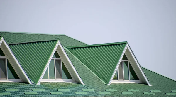 La casa con ventanas de plástico y un techo verde de chapa corrugada. Techo verde de perfil de metal corrugado y ventanas de plástico . —  Fotos de Stock