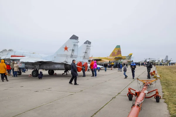 Militaire vliegtuigen strijders en andere vliegtuigen op het vliegveld van Krasnodar. Tentoonstelling van militair materieel ter ere van de verdedigers van het vaderland. Feestelijke gebeurtenis. Mensen inspecteren militair materieel. — Stockfoto