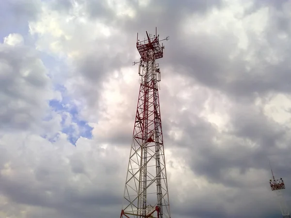 Torre celular. Torre de telecomunicações. Torre de comunicação contra o céu com nuvens . — Fotografia de Stock