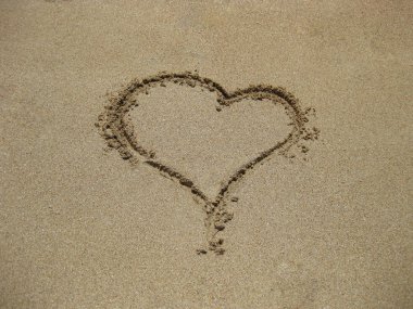 kalp kum üzerinde el ile kişi çizilmiş