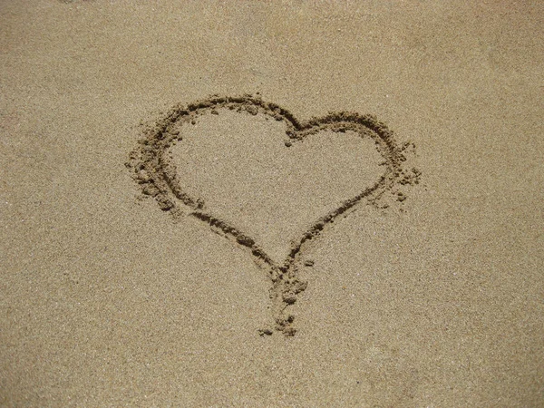 kalp kum üzerinde el ile kişi çizilmiş